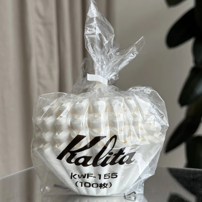 Bag of Kalita coffee filters with visible branding on a neutral background