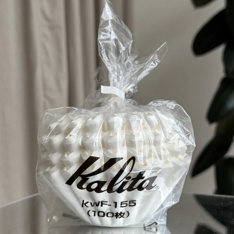 Bag of Kalita coffee filters with visible branding on a neutral background