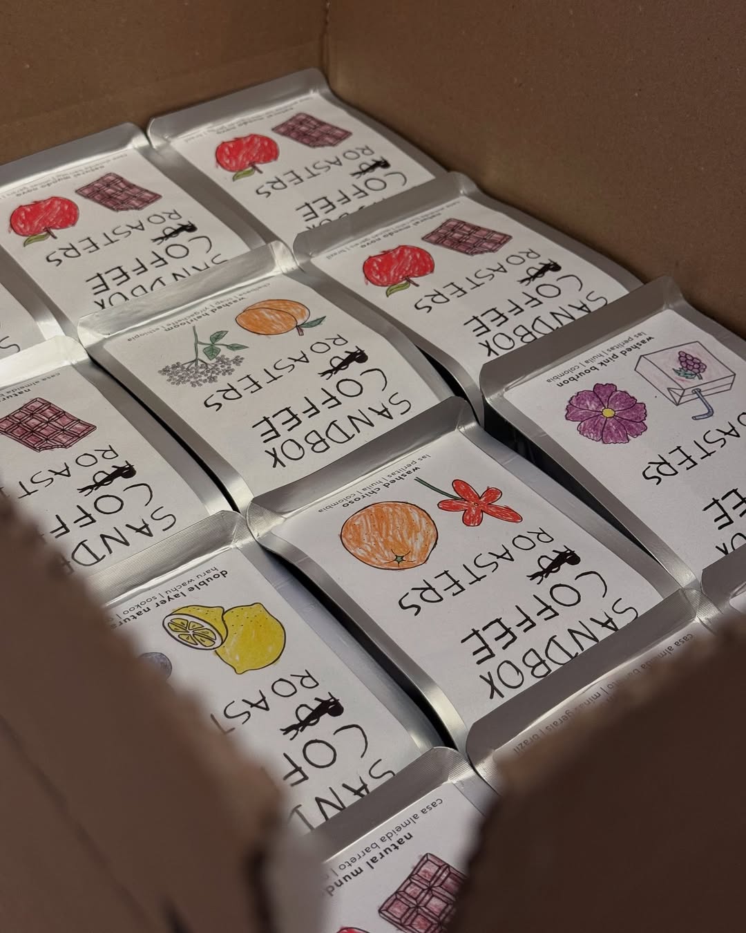 Packaging of coffee roaster products with illustrations on a cardboard surface
