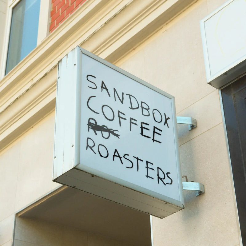 Sign for Sandbox Coffee Roasters on a building exterior