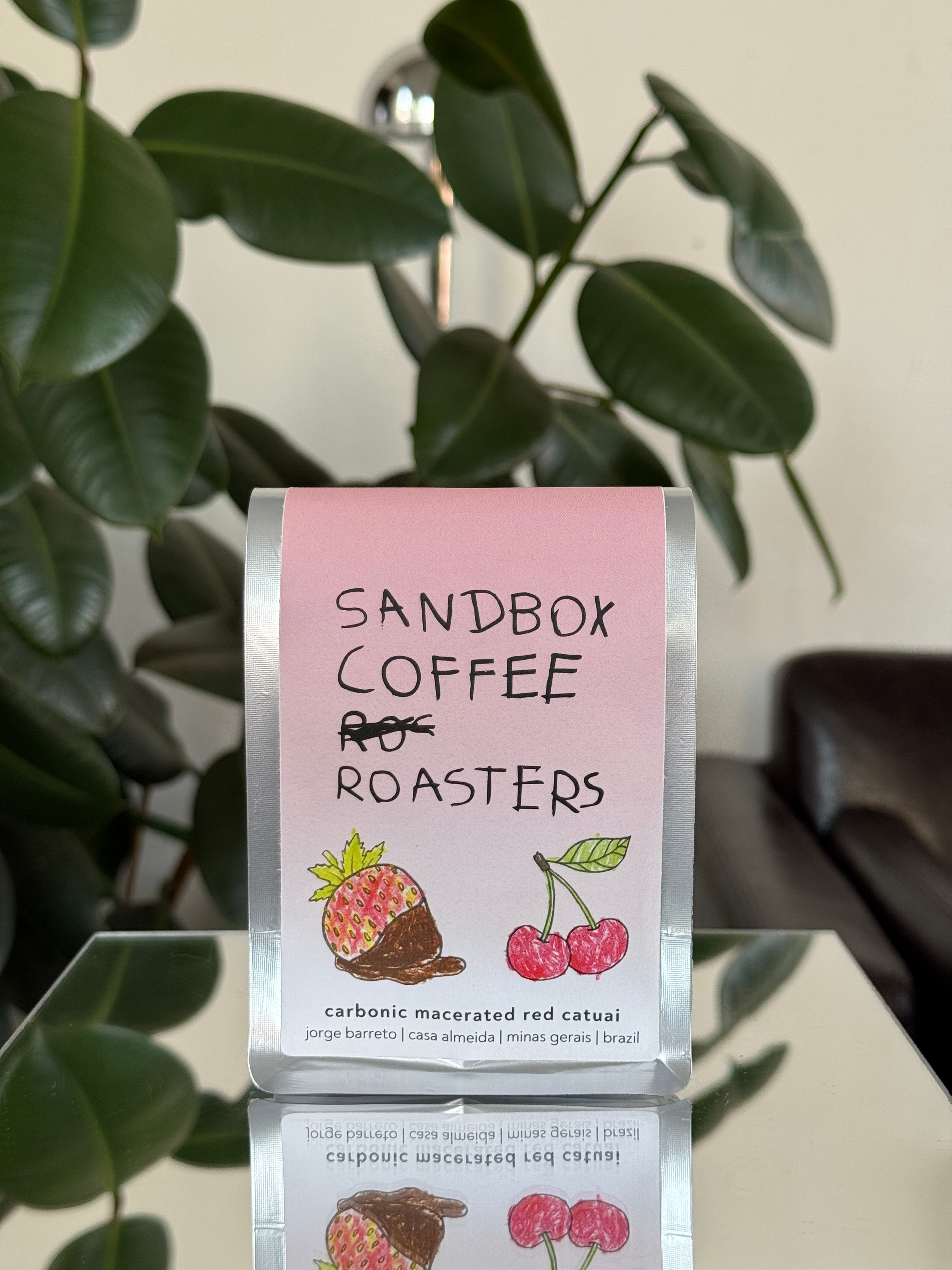Sandbox Coffee Roasters packaging with a pink label against a neutral background
