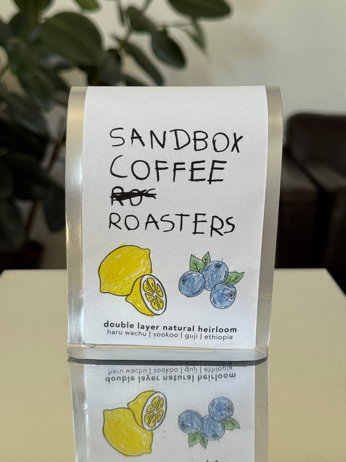 Sandbox Coffee Roasters packaging with lemons and blueberries on a neutral background