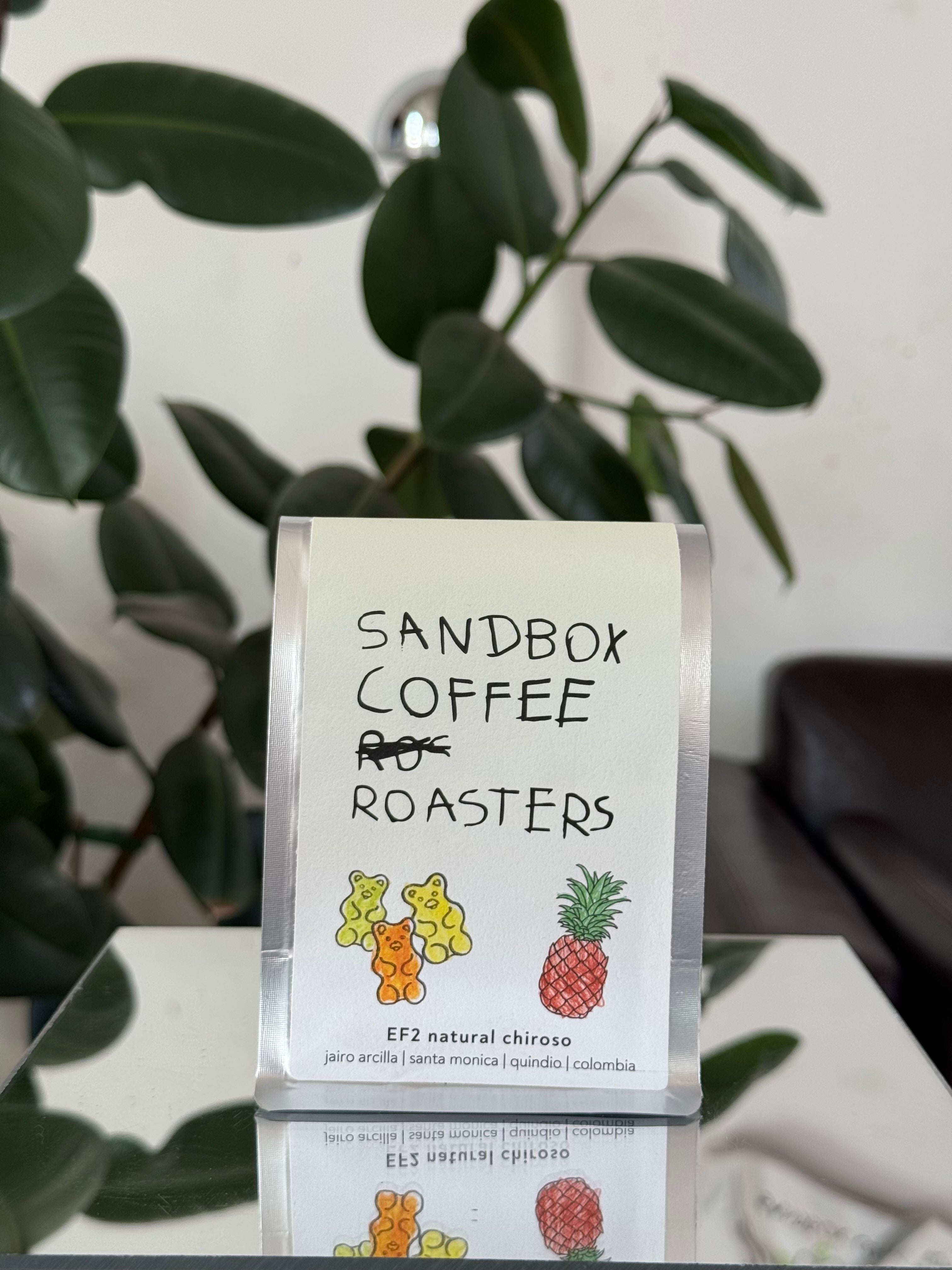 Sandbox Coffee Roasters package with a plant in the background