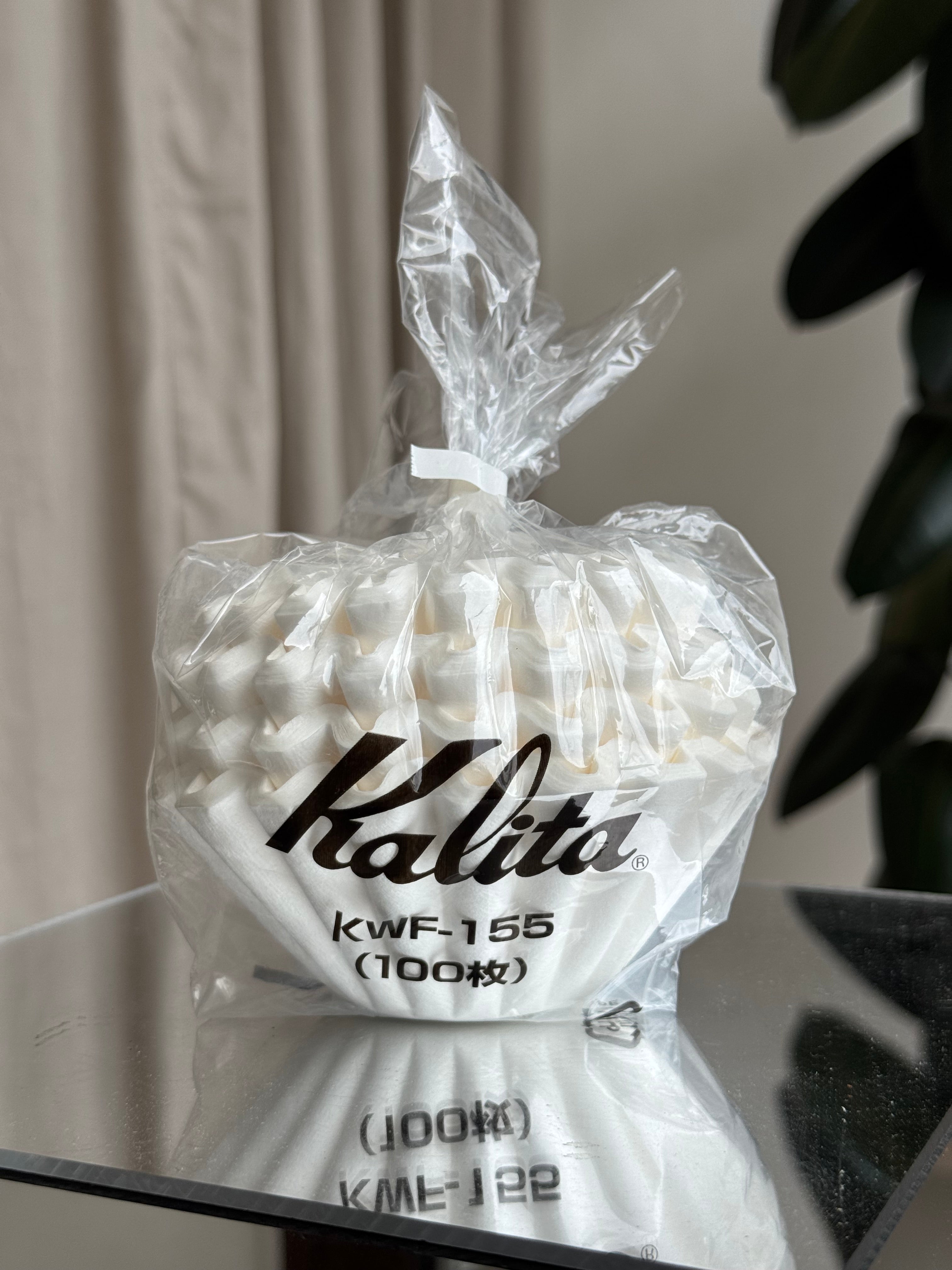 Kalita KWF-155 coffee filter papers in plastic packaging on a reflective table