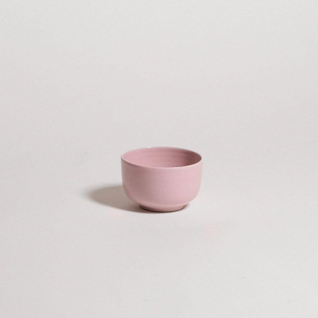 Pink ceramic cup on a light gray background