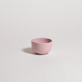 Pink ceramic cup on a light gray background