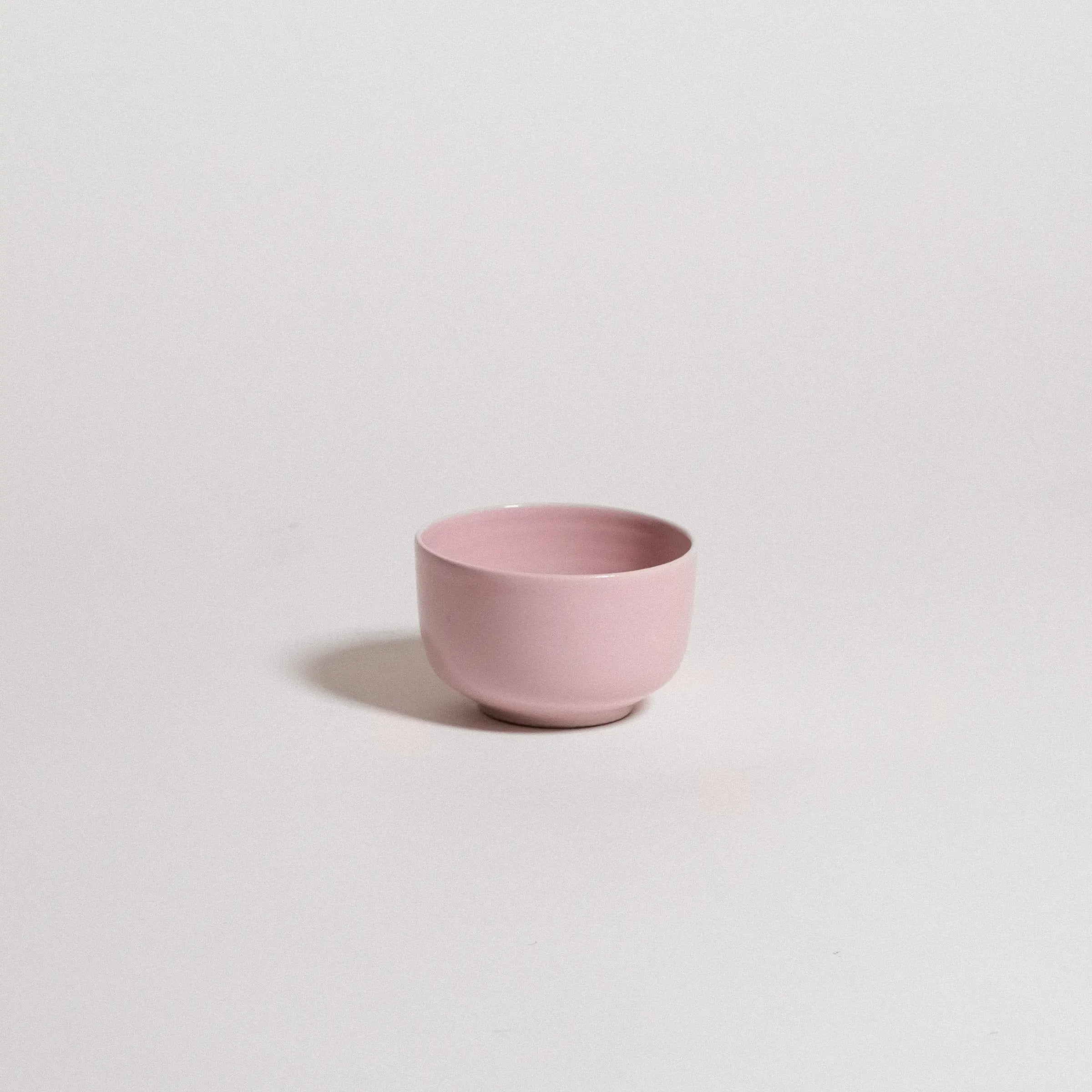 Pink ceramic cup on a light gray background