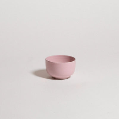 Pink ceramic cup on a light gray background