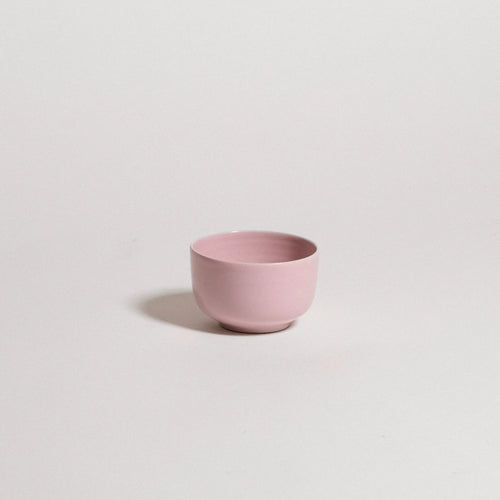 Pink ceramic cup on a light gray background